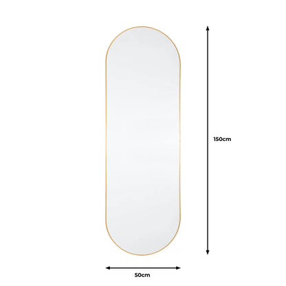 Full-length Gallery Yardley Gold Leaner Mirror with a rounded gold iron frame standing vertically in a bright modern living space reflecting natural sunlight.
