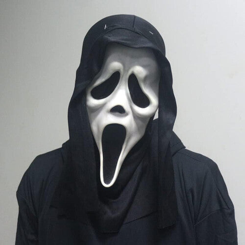 Front view of an adult wearing a classic white Ghost Face horror mask with an integrated black cloth hood in a dark setting