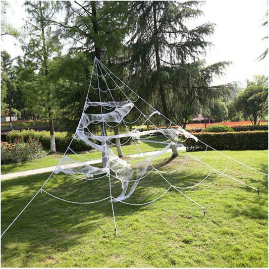 Large white 5M giant spider web stretched from a house roofline down to a grass lawn secured with ground stakes.