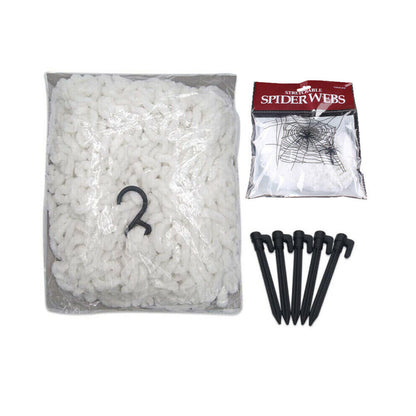 Large white 5M giant spider web stretched from a house roofline down to a grass lawn secured with ground stakes.
