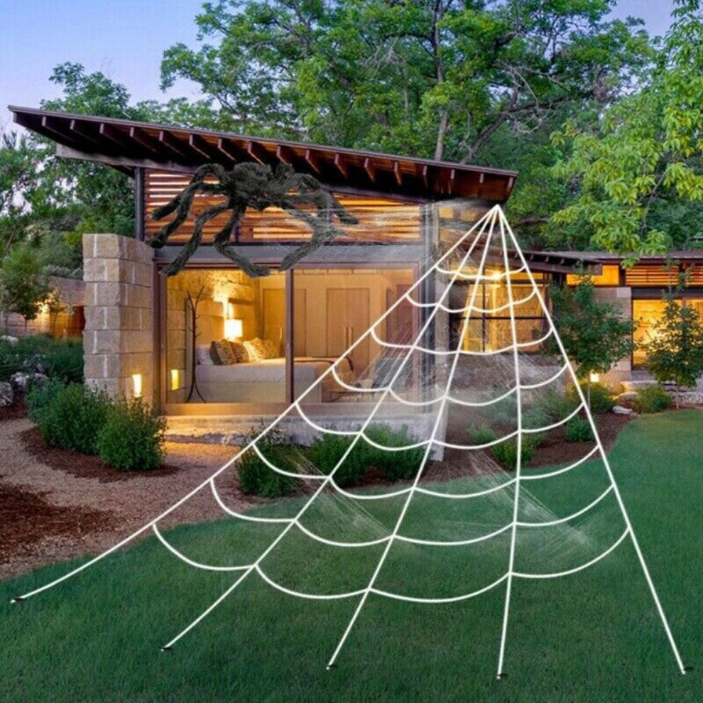 Large white 5M giant spider web stretched from a house roofline down to a grass lawn secured with ground stakes.
