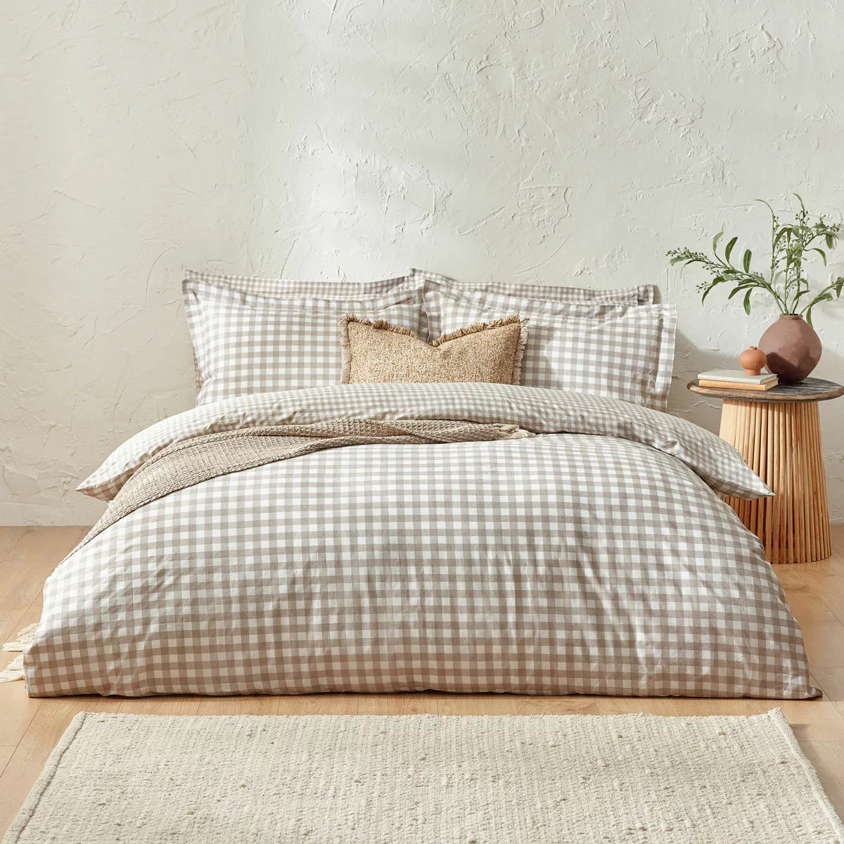 Flat-lay view of the single natural cotton gingham duvet cover set showcasing the reversible beige-and-white check pattern and structured Oxford border pillowcase on a rustic wood background.