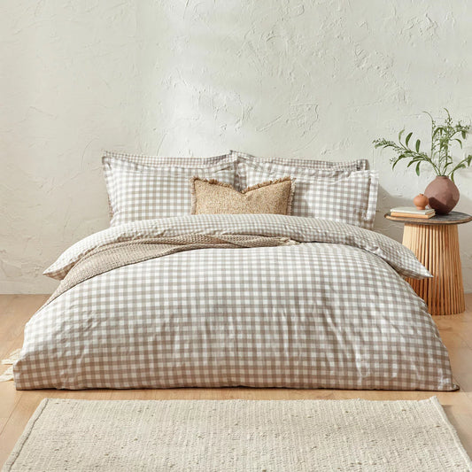 Flat-lay view of the single natural cotton gingham duvet cover set showcasing the reversible beige-and-white check pattern and structured Oxford border pillowcase on a rustic wood background.