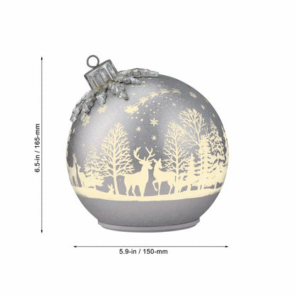 Pair of illuminated frosted glass rotating ball ornaments featuring etched reindeer and winter forest scenes glowing on a modern mantelpiece.