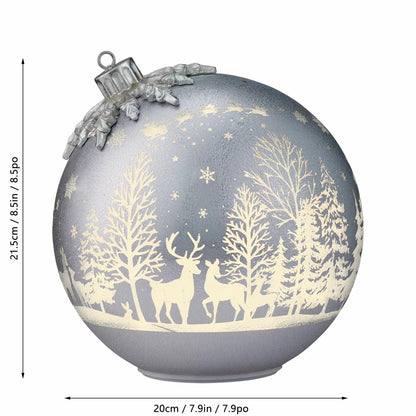 Pair of illuminated frosted glass rotating ball ornaments featuring etched reindeer and winter forest scenes glowing on a modern mantelpiece.