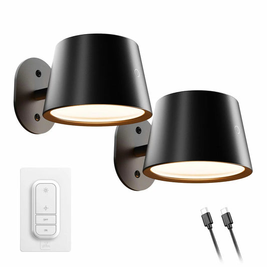 Pair of modern matte black Globe rechargeable wall lights mounted beside a bed with 360-degree swivel heads illuminating a cozy bedroom interior.