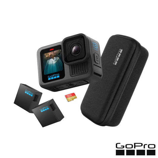 Front view of the black GoPro HERO13 action camera mounted on a tripod alongside extra Enduro batteries and a 128GB SanDisk memory card on a dark surface.