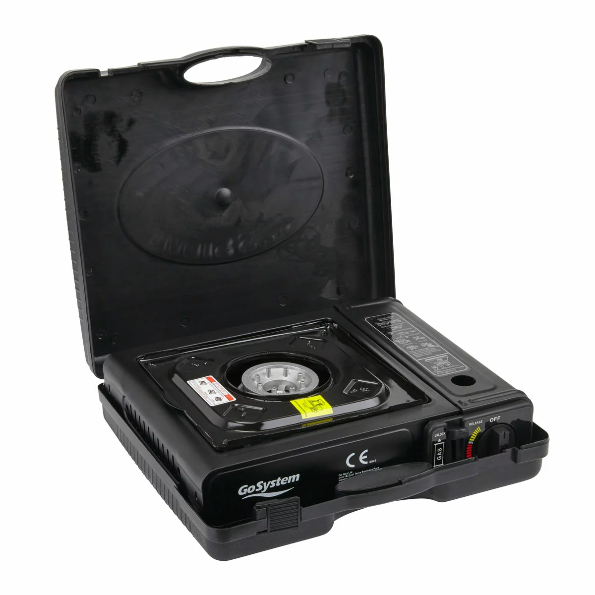 Compact black metal GoSystem Dynasty Compact II single-burner stove with serrated pan supports sitting on a wooden picnic bench next to its hardshell carrying case.