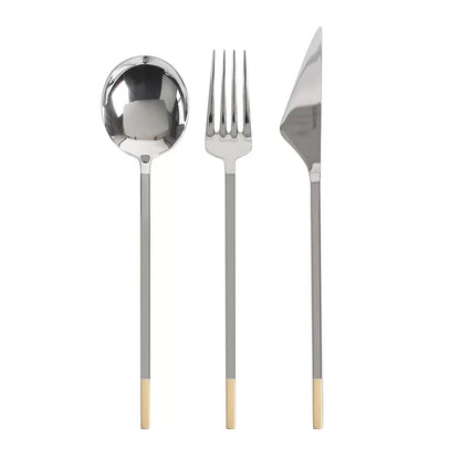 A close-up shot of the Golden Bell 24-piece cutlery set neatly arranged on a dark linen tablecloth, highlighting the polished silver 18/10 stainless steel texture and the gleaming gold-plated handles