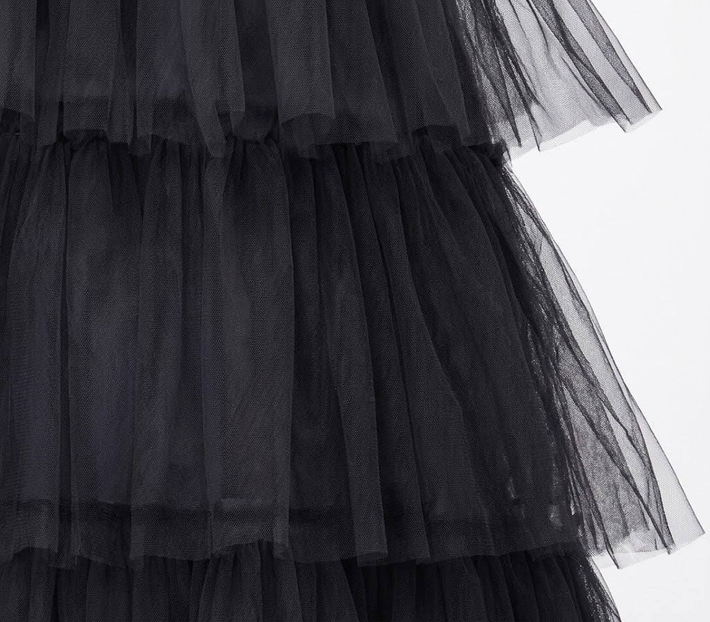 Front angle shot of a child sized 5-6 wearing a floor-length black gothic queen dress with lace bell sleeves and ruffled skirts.