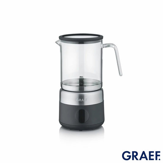 Front angle view of the black Graef MS802UKI Milk Frother with its clear glass jug mounted on the base station displaying rich white milk foam.