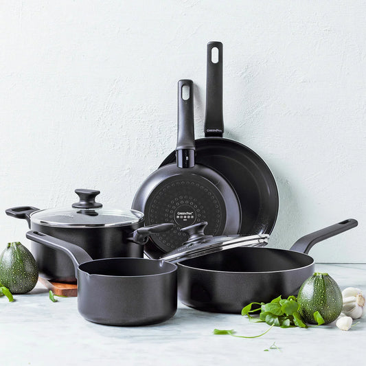A complete 9-piece GreenPan Essence cookware set in a sleek black finish, arranged neatly on a modern marble kitchen countertop.