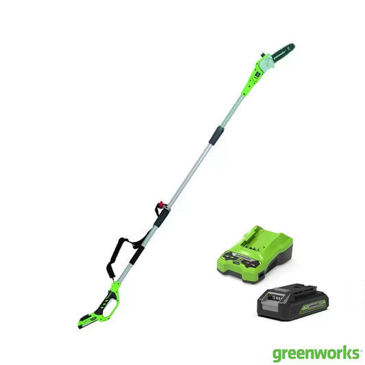 Greenworks 24V cordless pole saw being used to trim a high tree branch from the ground.