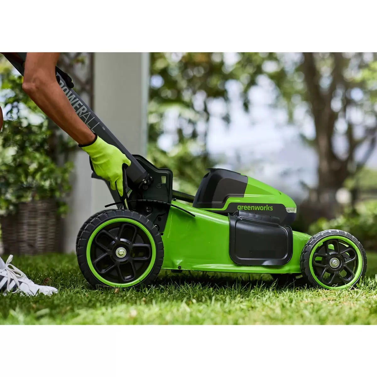 Greenworks 48V self-propelled cordless lawn mower with 46cm cutting deck mowing a large residential garden