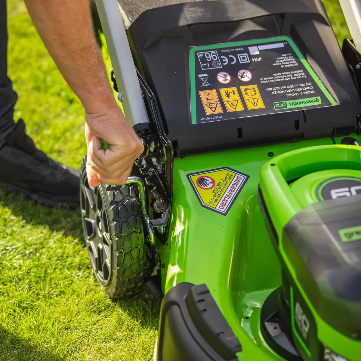 Greenworks 60V 46cm self-propelled cordless lawnmower with 4Ah battery mowing a large residential garden