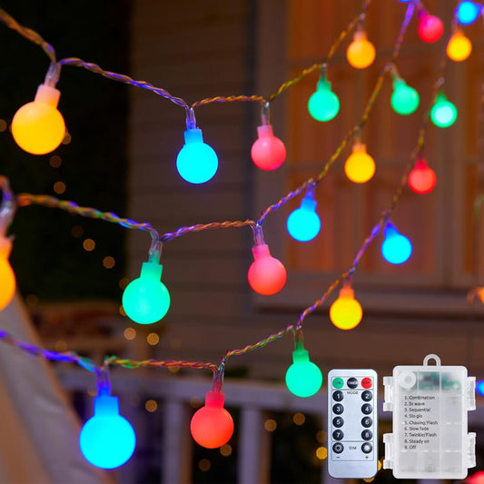 A string of 30 green LED eyeball lights glowing with eerie 3D realism along an outdoor porch railing.