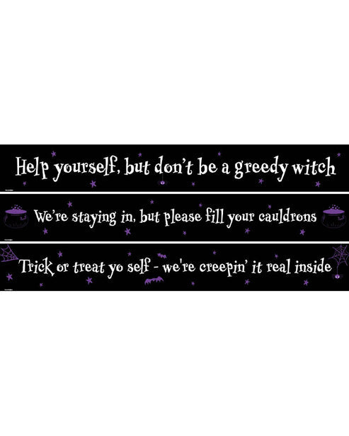 Three 1-meter Halloween paper banners with witty trick-or-treat self-service messages printed in bold black lettering laid flat on a rustic wooden surface.