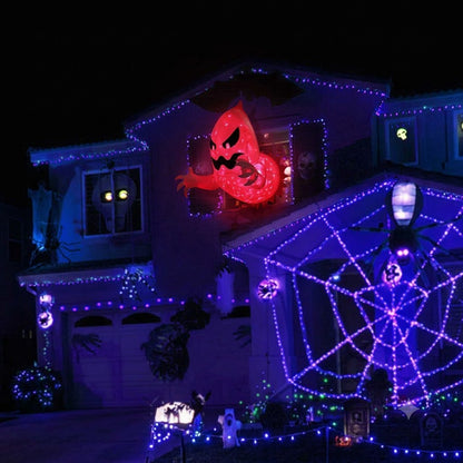 White polyester 4.6-foot inflatable Halloween ghost with internal red LED light bursting out of a house window frame at night.