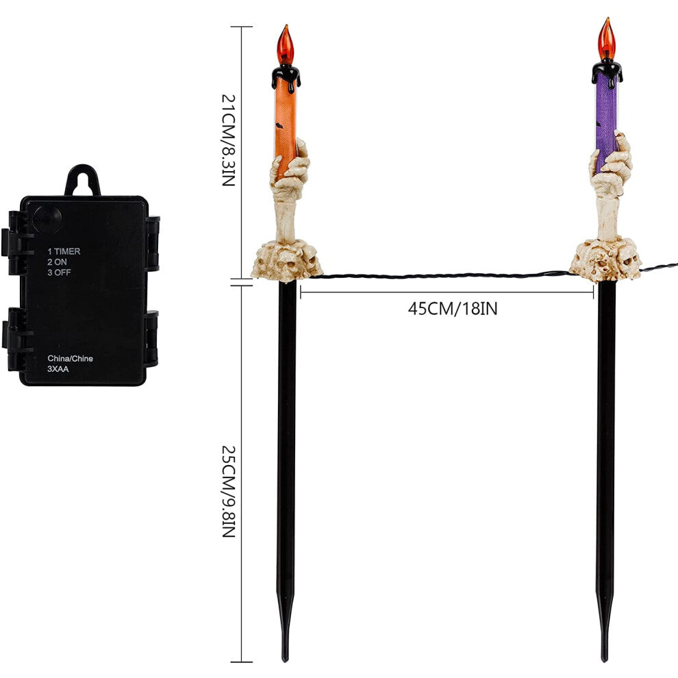 A 5-pack of Halloween lighted skeleton hand candle stakes glowing with warm white LEDs along a spooky outdoor garden lawn