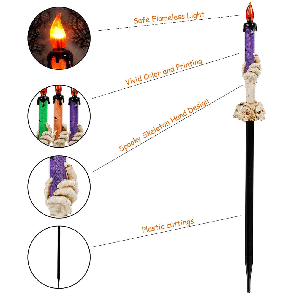 A 5-pack of Halloween lighted skeleton hand candle stakes glowing with warm white LEDs along a spooky outdoor garden lawn
