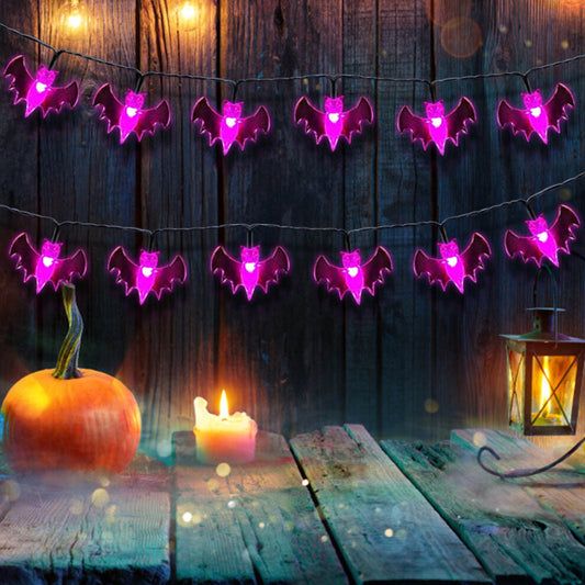 A 19.7ft multi-color Halloween string light featuring pumpkin, bat, and ghost motifs glowing brightly along an outdoor porch railing.