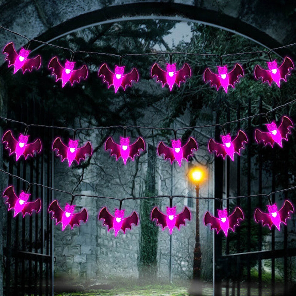 A 19.7ft multi-color Halloween string light featuring pumpkin, bat, and ghost motifs glowing brightly along an outdoor porch railing.