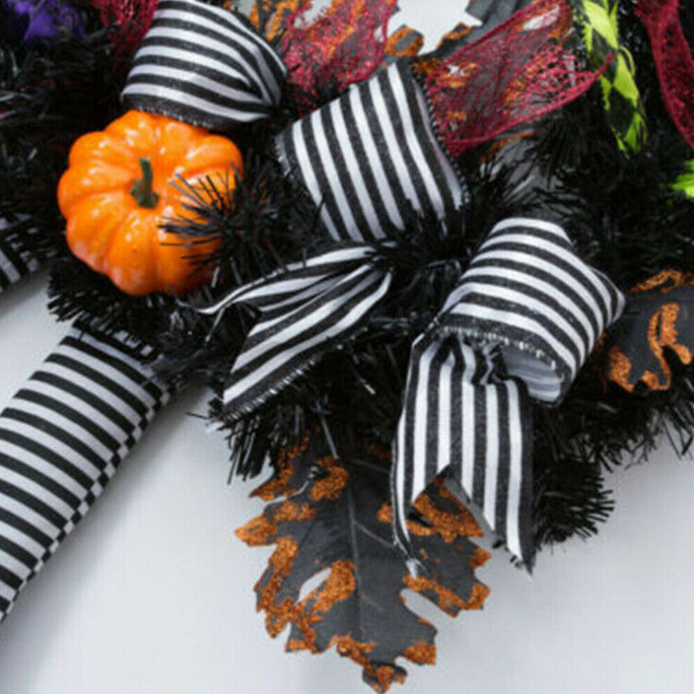 Black and orange Halloween witch door wreath with miniature broom, pointed hat, striped legs, and foam pumpkins hanging on a front door.