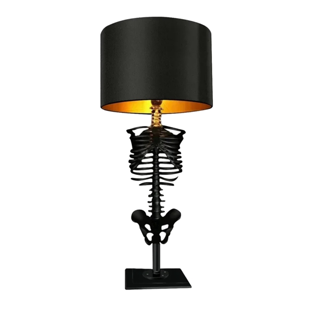 A Gothic resin skull desktop ambient light glowing on a dark workspace surface for Halloween party decoration.