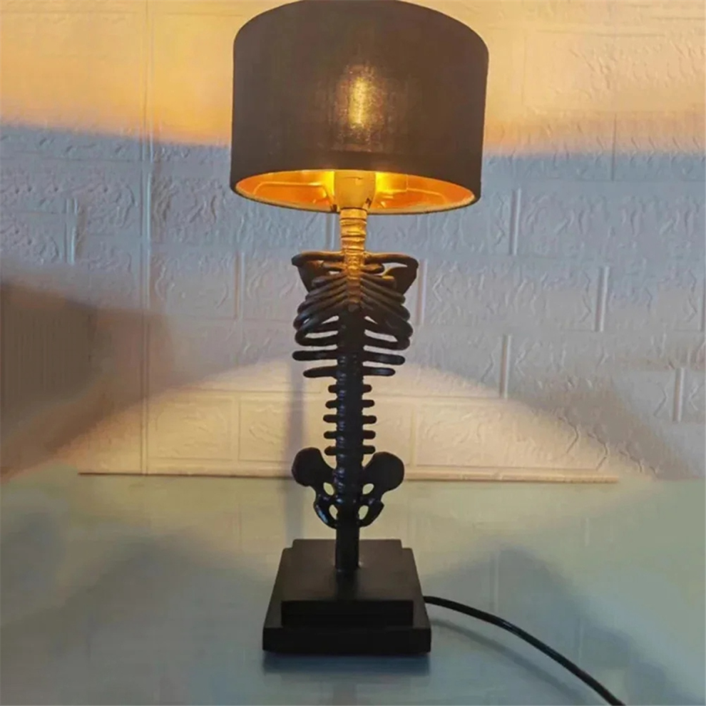 A Gothic resin skull desktop ambient light glowing on a dark workspace surface for Halloween party decoration.