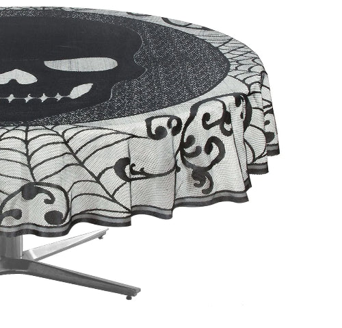 A 70-inch Halloween skull lace tablecloth spread over a dark wooden dining table, styled with black candles and miniature pumpkins under atmospheric lighting