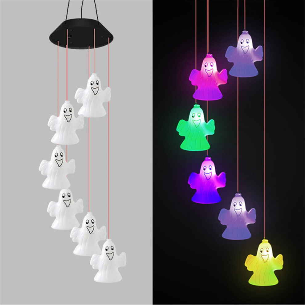 A colorful solar-powered Halloween wind chime lantern hanging from an outdoor porch ceiling, glowing with slow-flashing multi-color LEDs.