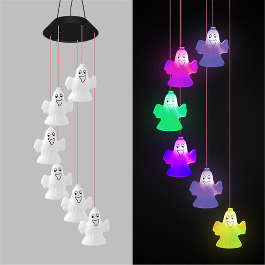 A colorful solar-powered Halloween wind chime lantern hanging from an outdoor porch ceiling, glowing with slow-flashing multi-color LEDs.