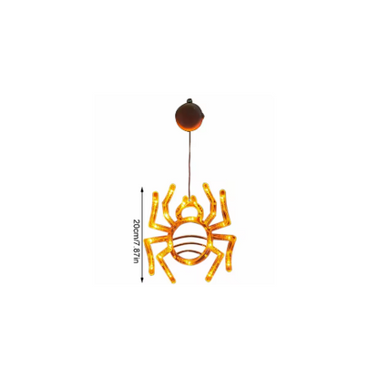 An illuminated Halloween window LED light with a suction cup glowing brightly against a glass pane at night.