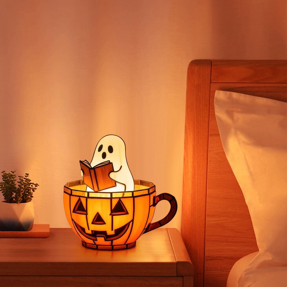 A handmade ghost reading a book lamp glowing with soft color-changing light on a wooden bookshelf decorated for Halloween.