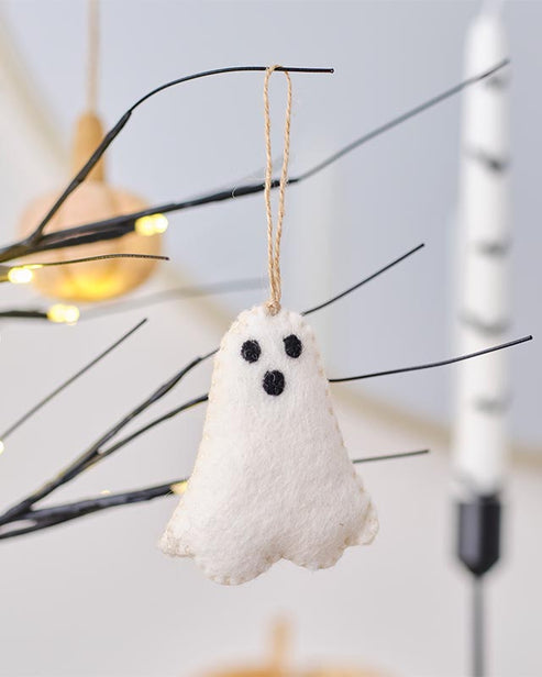 A 100cm white hanging ghost decoration with flowing tattered fabric suspended from a dark autumn tree branch outdoors.