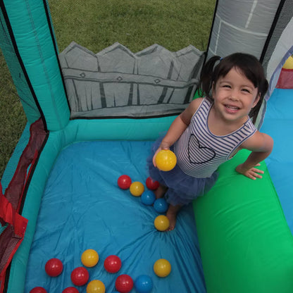 Colourful Happy Hop inflatable bouncy castle with integrated slide and enclosed ball pit set up on a green garden lawn during outdoor family play-2