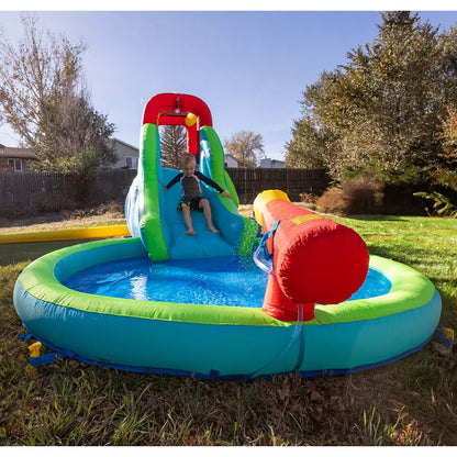 Colourful Happy Hop inflatable water slide pool with climbing wall, bounce area, splash pool and water cannon set up on a sunny garden lawn for children's outdoor summer play.