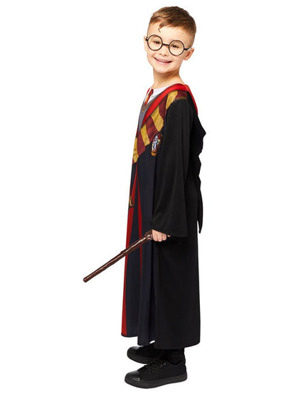 Front view of child wearing deluxe Harry Potter black robe with embroidered house crest and red satin hood lining in studio lighting.