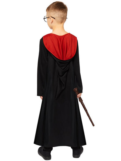 Front view of child wearing deluxe Harry Potter black robe with embroidered house crest and red satin hood lining in studio lighting.