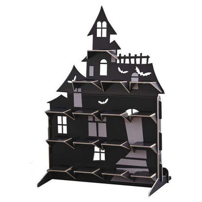 Black multi-tiered haunted house treat stand displayed on a Halloween party table filled with frosted cupcakes and dark candies.