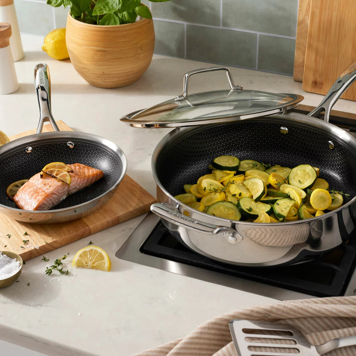 Henckels Paradigm 11-piece stainless steel cookware set with pots, pans, and lids for even heat distribution and everyday cooking
