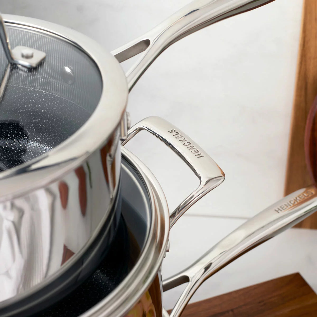 Henckels Paradigm 11-piece stainless steel cookware set with pots, pans, and lids for even heat distribution and everyday cooking