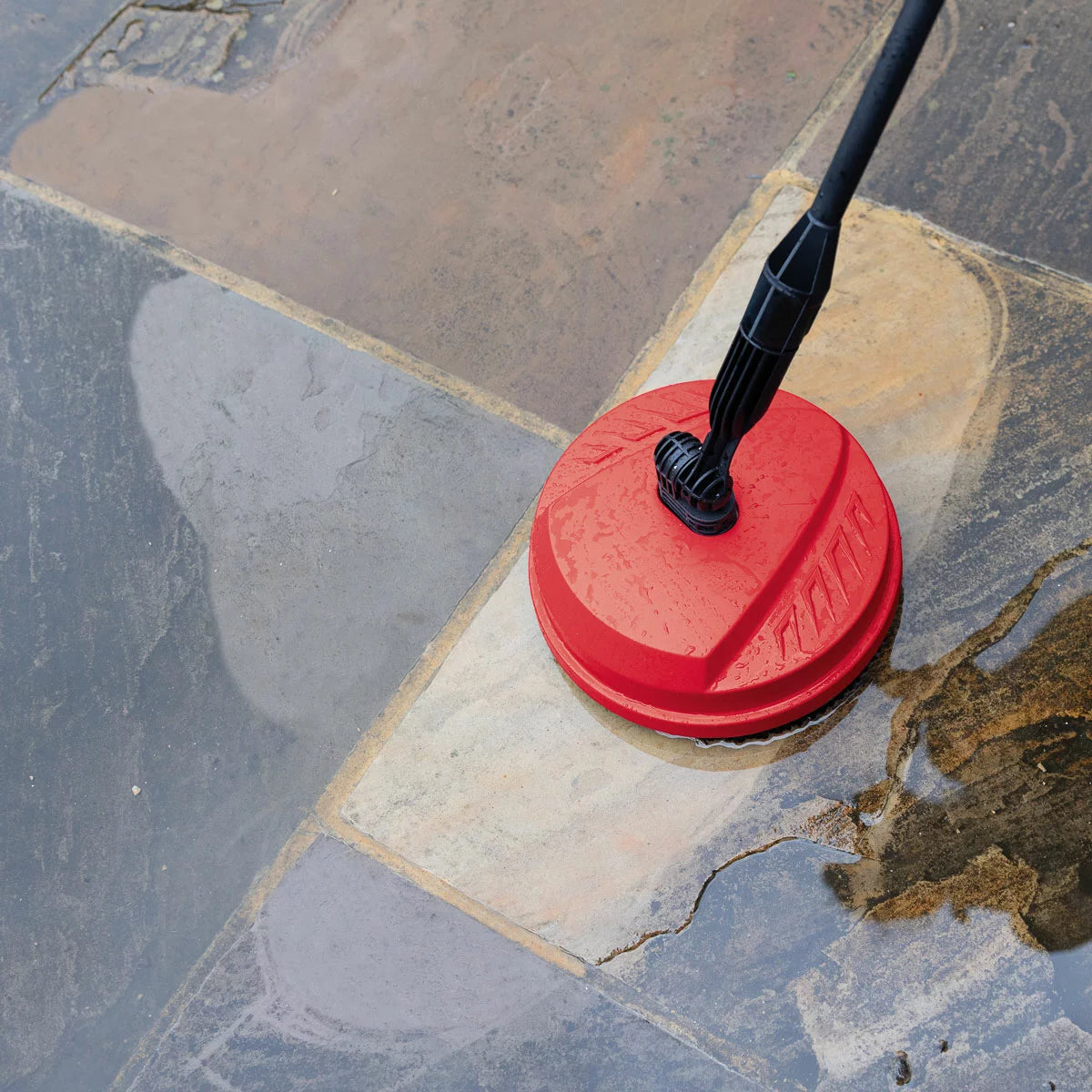 A compact Hilka 1600W pressure washer shown with its patio cleaner attachment, high-pressure nozzle, and foam bottle, set against a clean residential driveway.