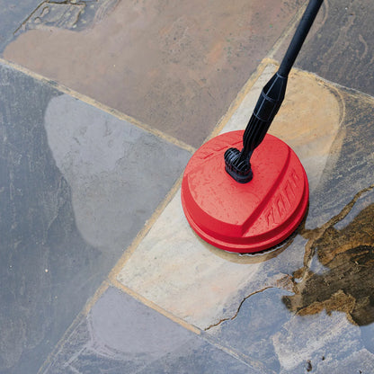 A compact Hilka 1600W pressure washer shown with its patio cleaner attachment, high-pressure nozzle, and foam bottle, set against a clean residential driveway.