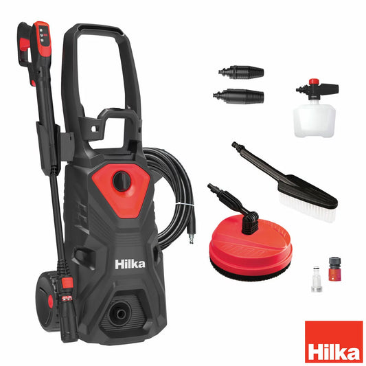 A Hilka 2,000W pressure washer set up on a residential driveway, with various attachments including the patio cleaner and foam bottle neatly arranged nearby.