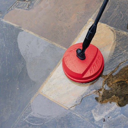 A Hilka 2,000W pressure washer set up on a residential driveway, with various attachments including the patio cleaner and foam bottle neatly arranged nearby.