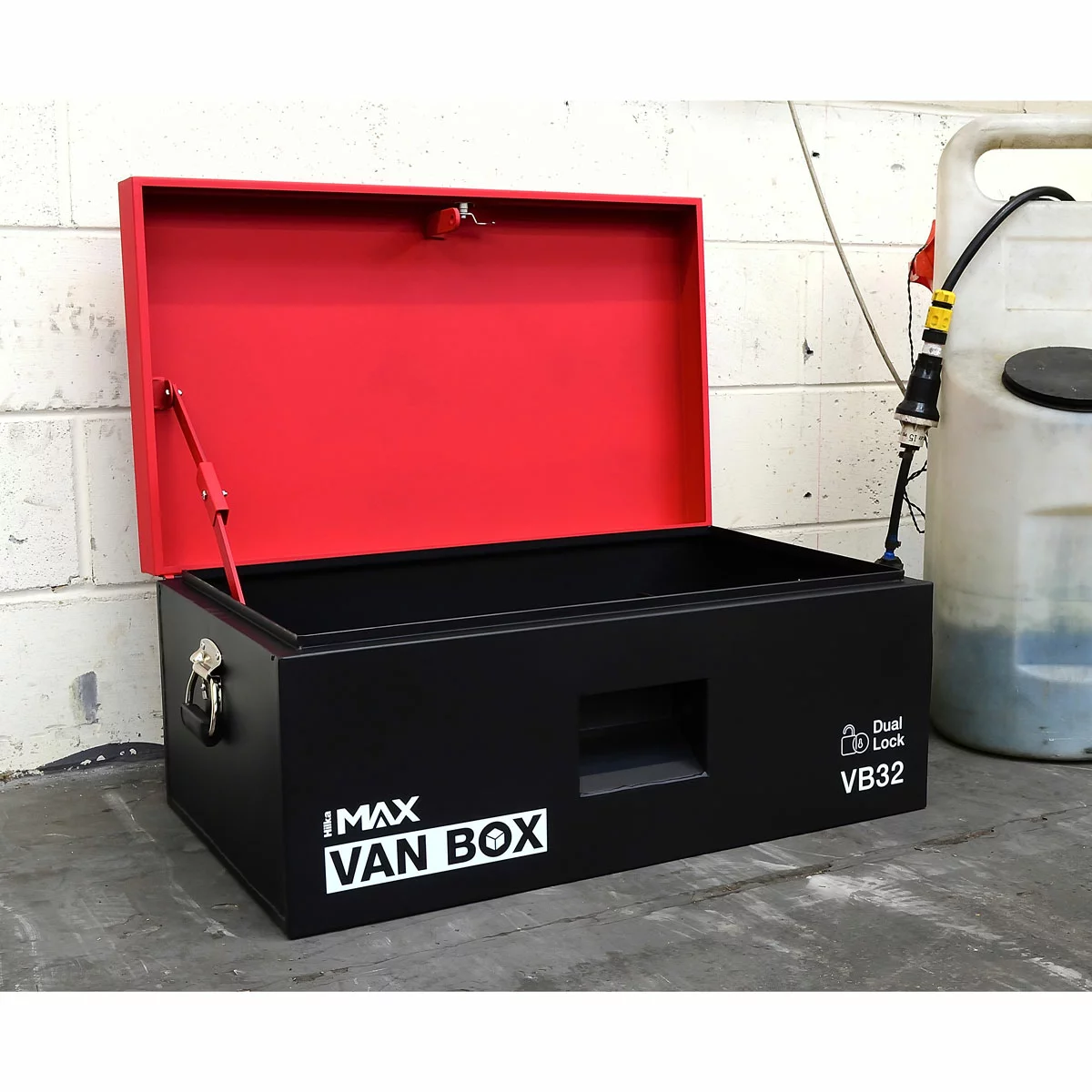 Industrial matte-finish grey steel Hilka 32-inch heavy duty van storage box showing its recessed locking ports and reinforced piano-hinge lid in the back of a professional transit work vehicle.