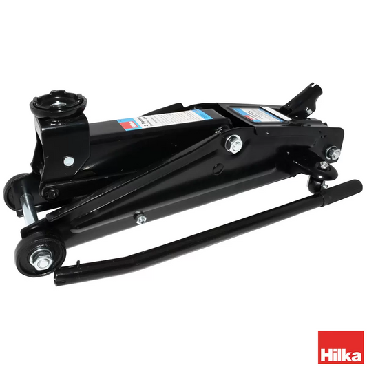 Heavy-duty red steel Hilka 3 Tonne Trolley Jack positioned underneath a black 4x4 SUV chassis on a clean concrete garage floor.