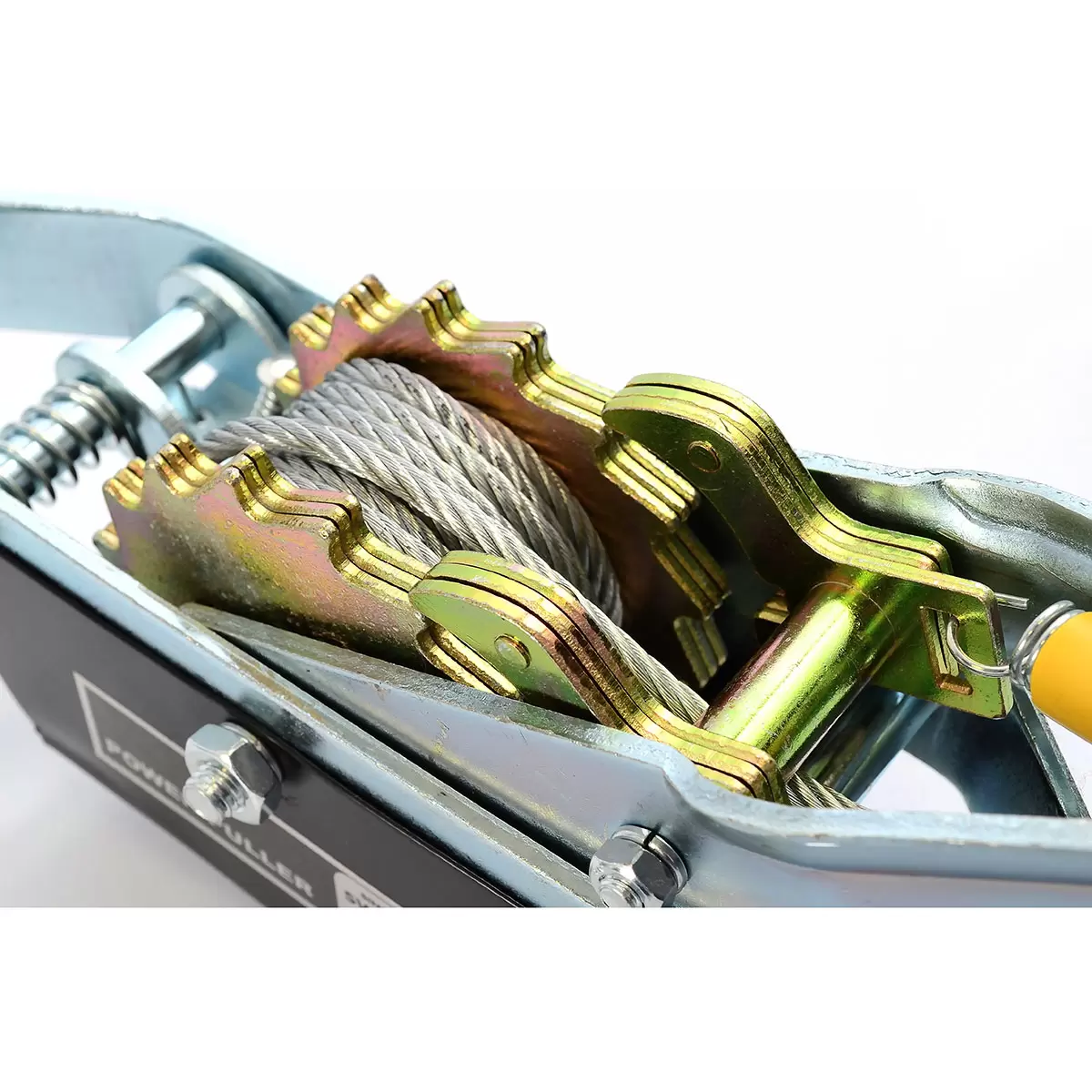 Heavy-duty steel Hilka Pro-Craft 800KG twin-ratchet power puller laying on grass next to an off-road vehicle tyre, showcasing its thick braided steel cable and three drop-forged steel hooks.