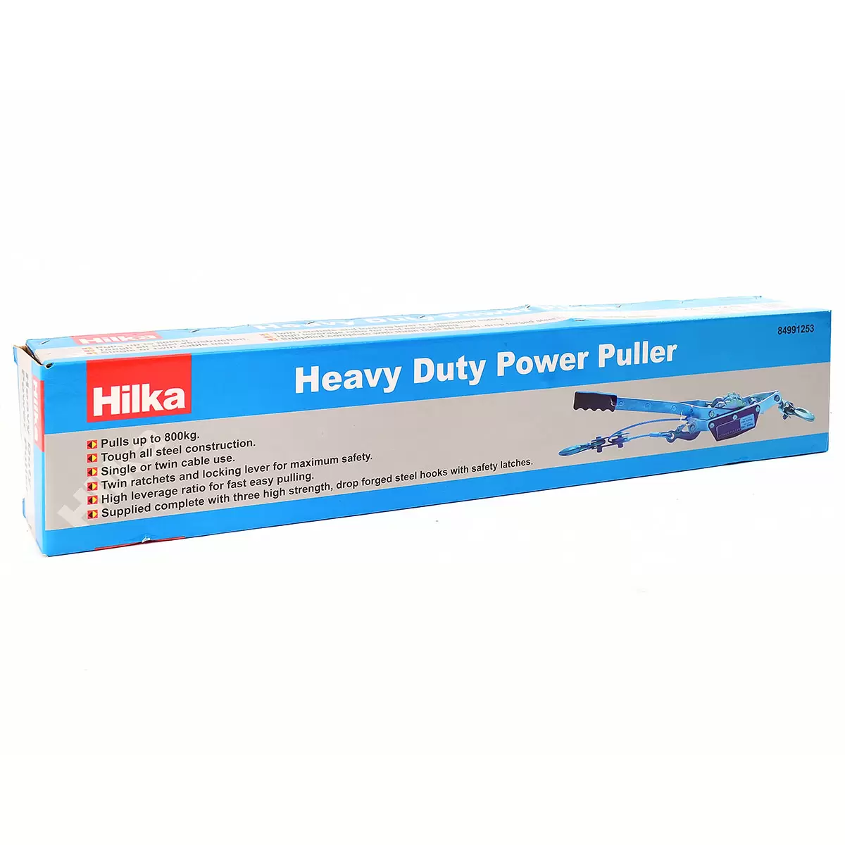 Heavy-duty steel Hilka Pro-Craft 800KG twin-ratchet power puller laying on grass next to an off-road vehicle tyre, showcasing its thick braided steel cable and three drop-forged steel hooks.